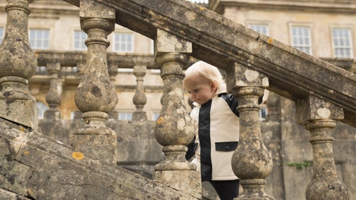 Young boy walking up stone steps to a historic house